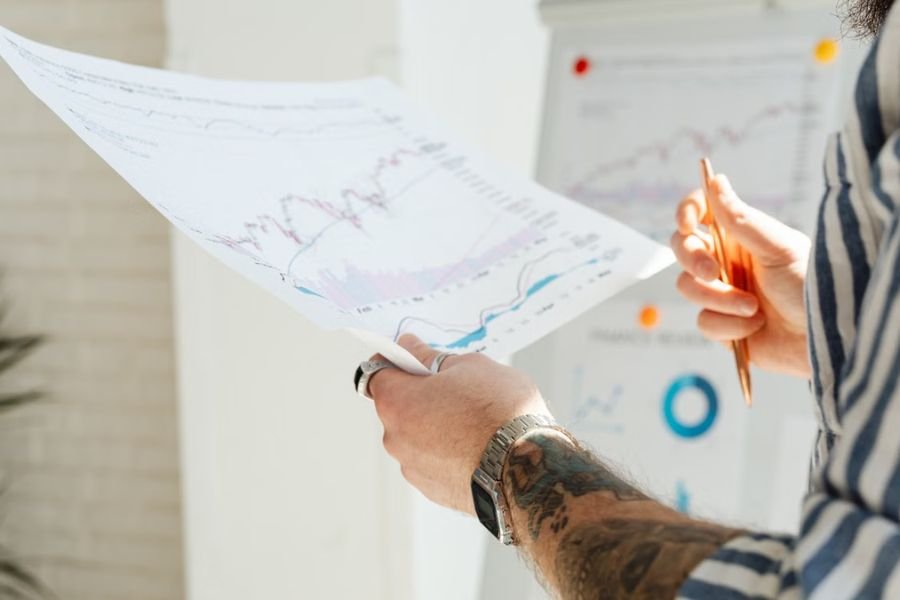 Business professional reviewing printed financial charts and reports