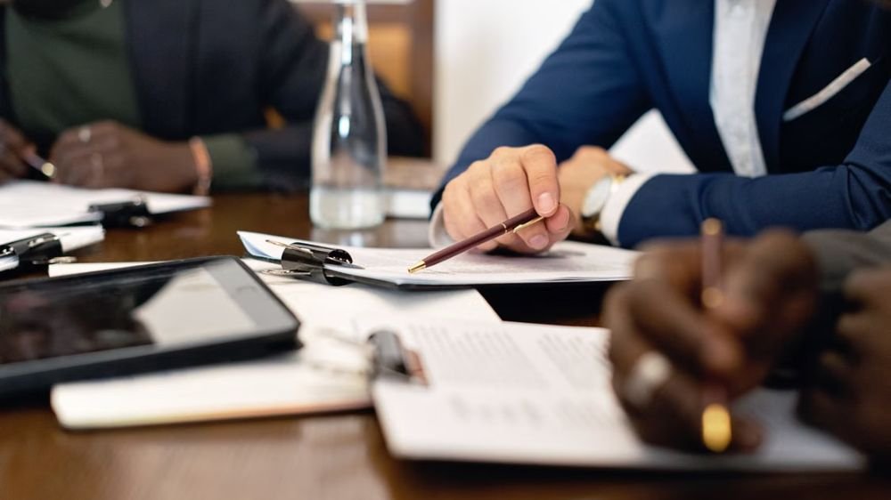 employers-reviewing-business-travel-insurance Business professionals reviewing documents during an office meeting