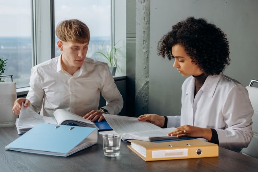 part-time-employee-health-insurance-planning Two professionals reviewing documents and benefit information at an office table