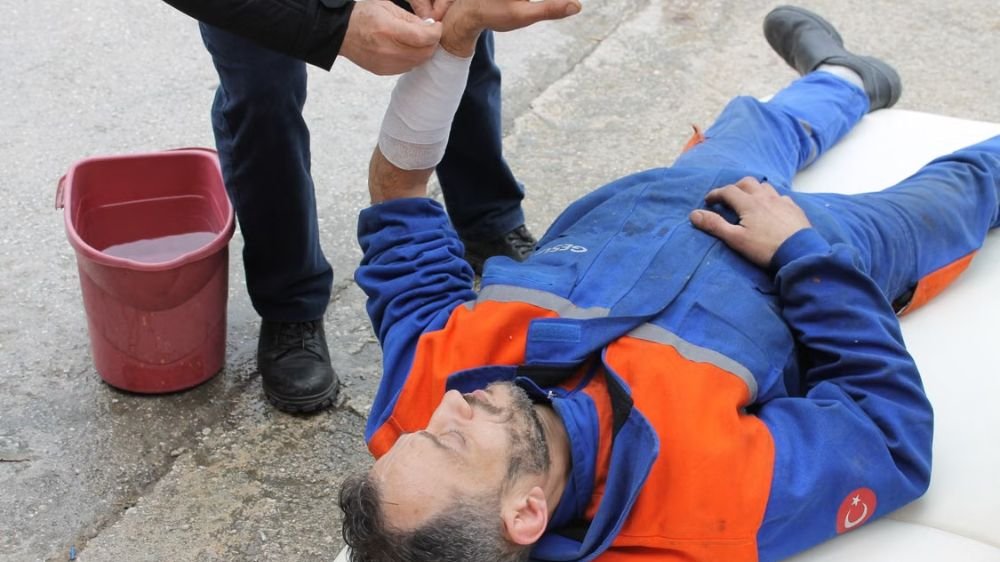 workplace-injury-workers-compensation Injured worker receiving first aid for a wrist injury at a job site
